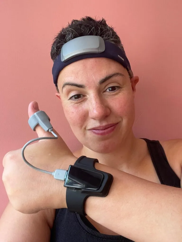 Caz Coronel wearing an EEG headband, a finger pulse sensor and a wrist-worn recorder